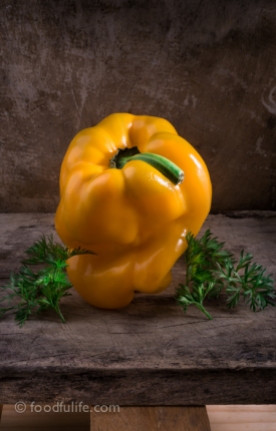 Yellow bell pepper with carrot leaves